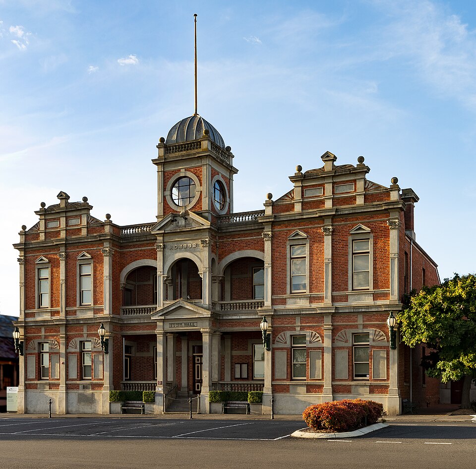 Red-brick town hall with pale stone details and a central clock tower.