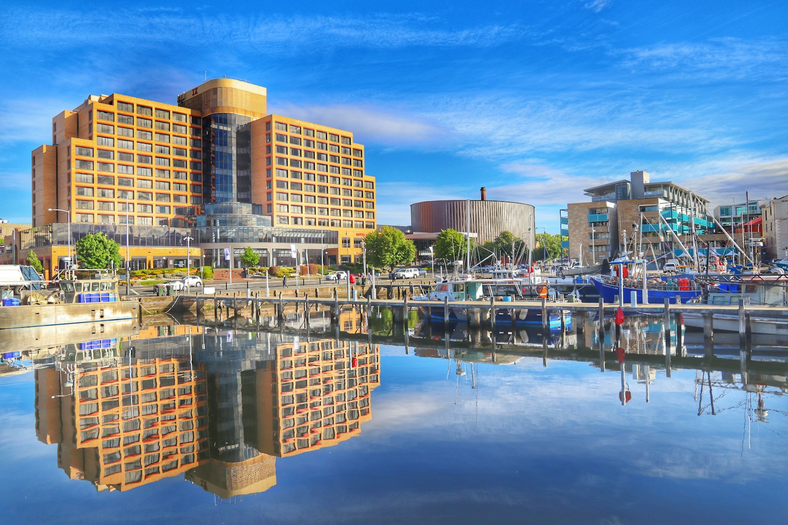 Boats and waterfront buildings reflected in still water at Hobart docks.