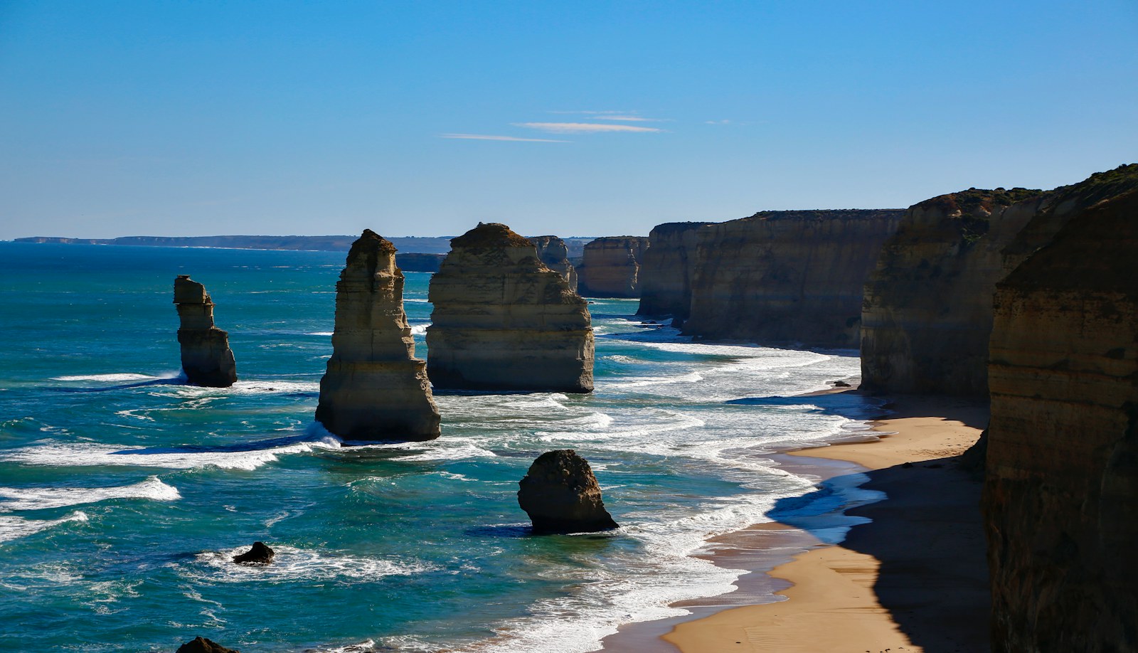 Limestone sea stacks and cliffs beside breaking waves at the Twelve Apostles.