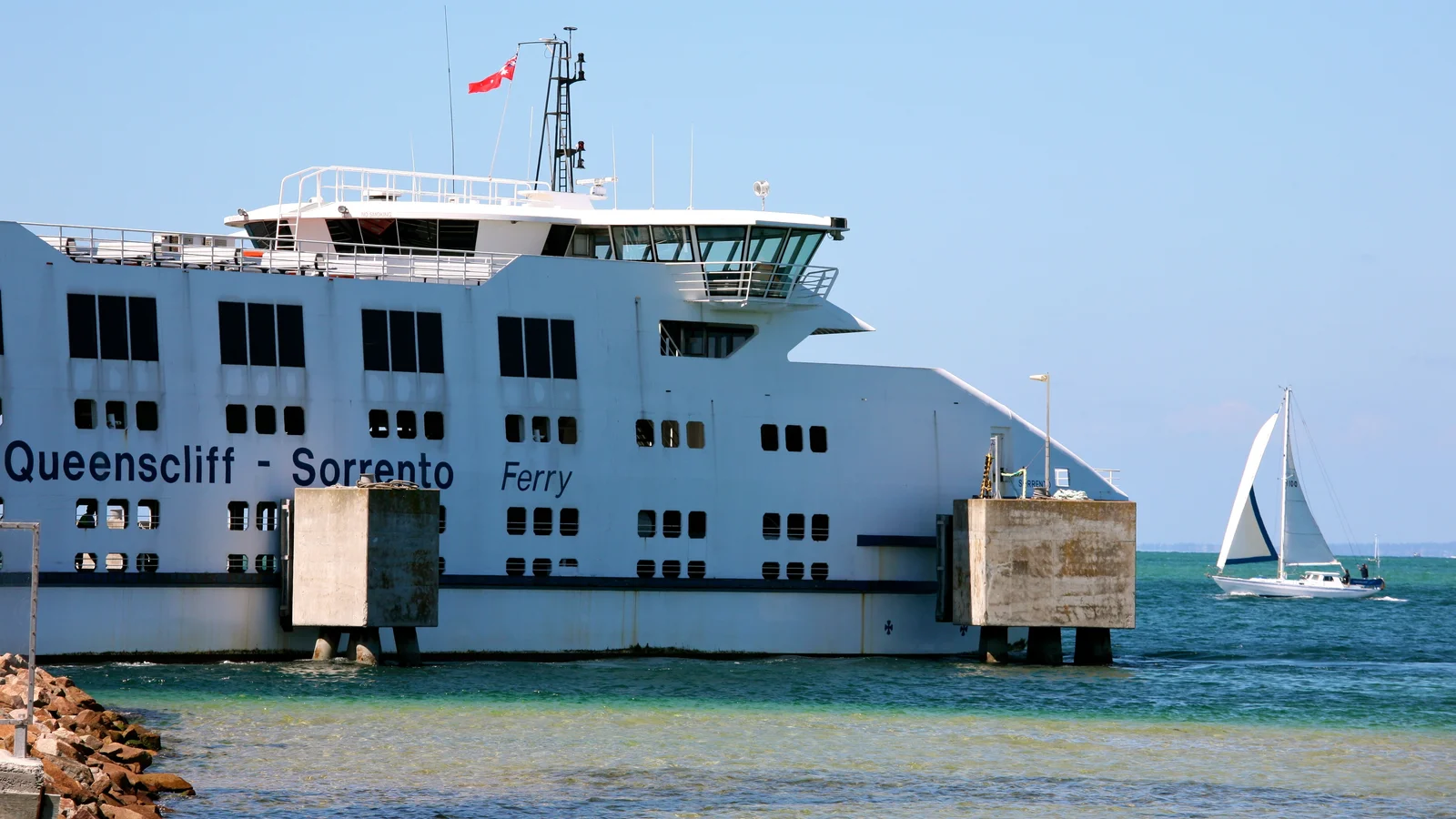 The Queenscliff–Sorrento ferry on blue water beside a small sailing boat