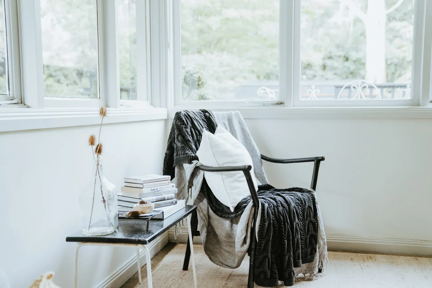 A chair and folded textile beside the window.