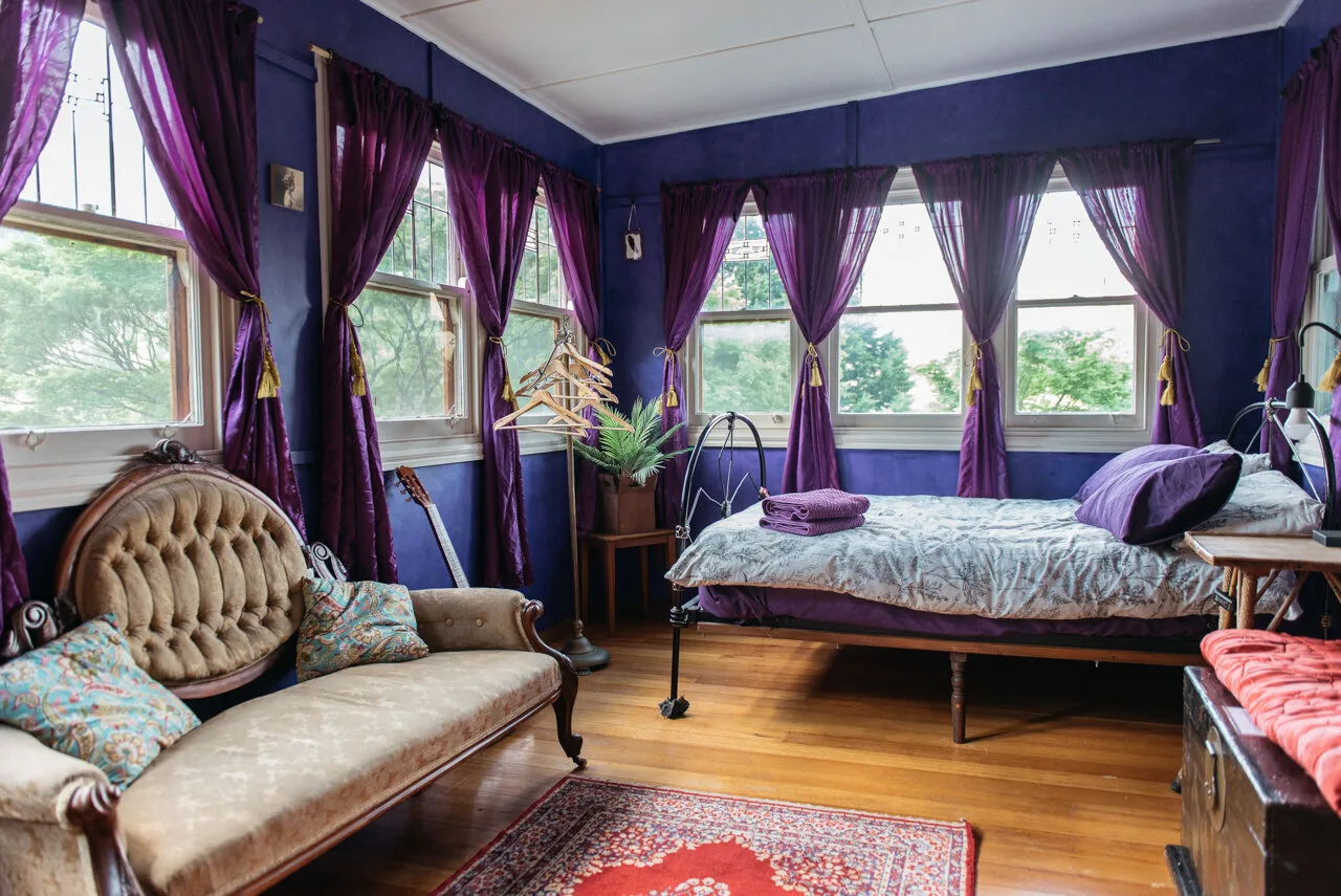 Purple curtains surround a window-lined sitting area.