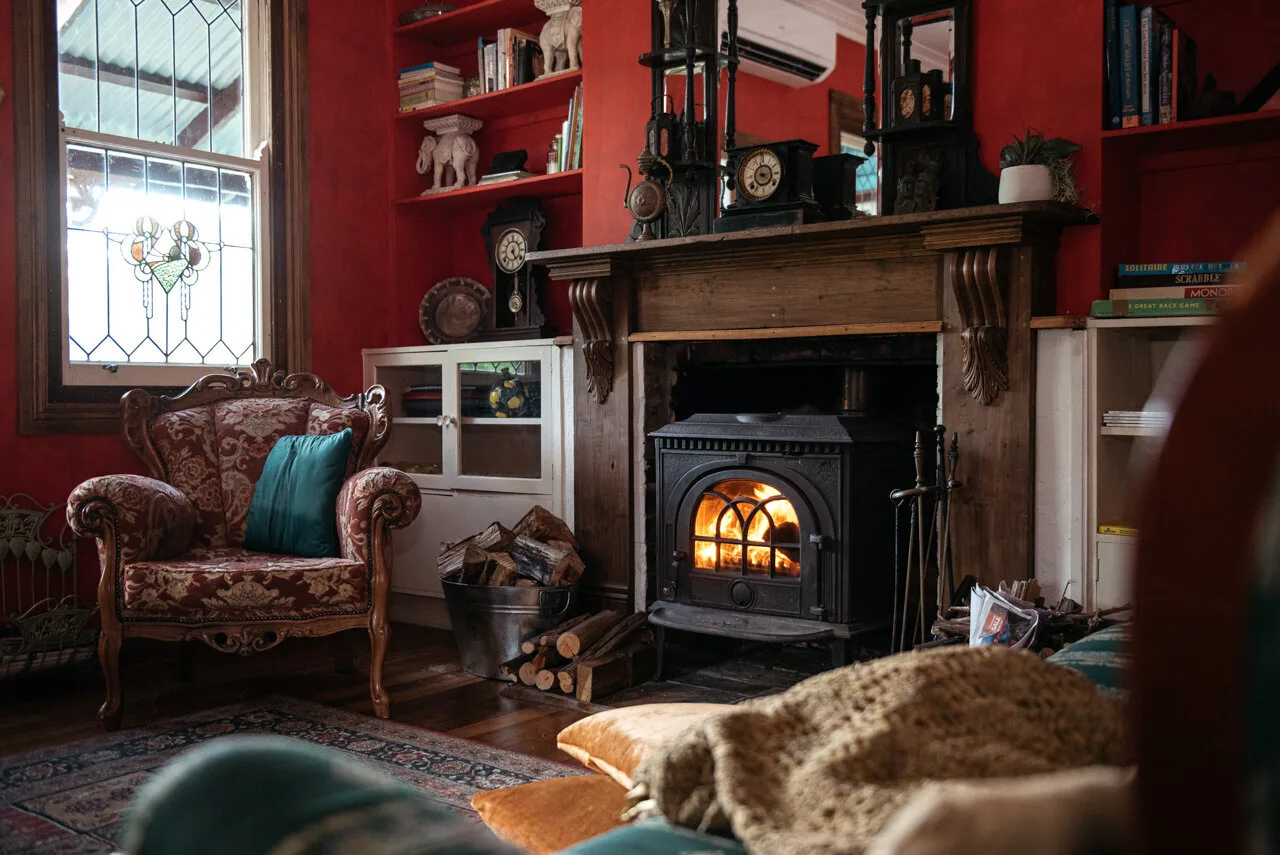A dark fireplace within a richly coloured room.