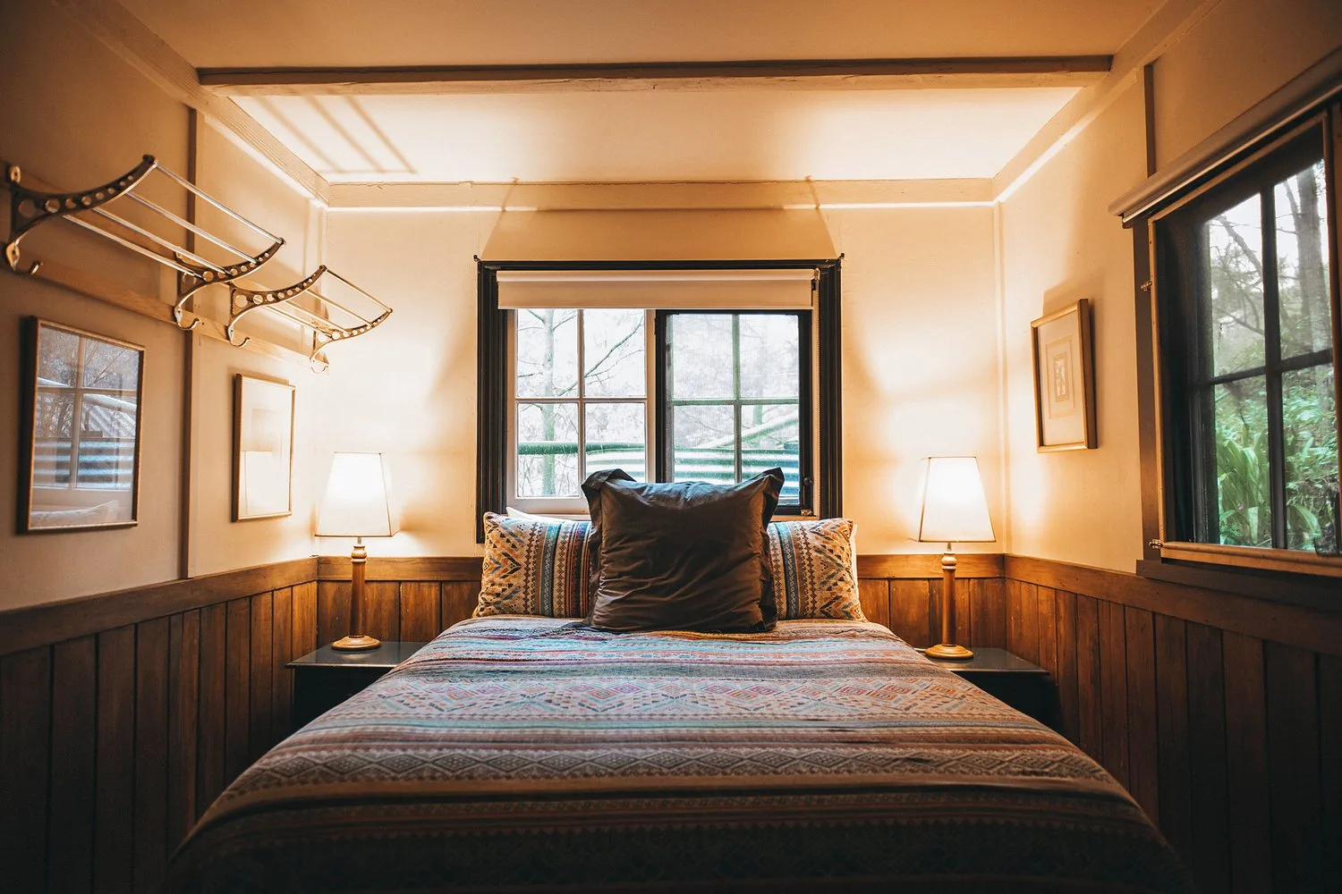 A bedroom with timber panelling and a bright window.