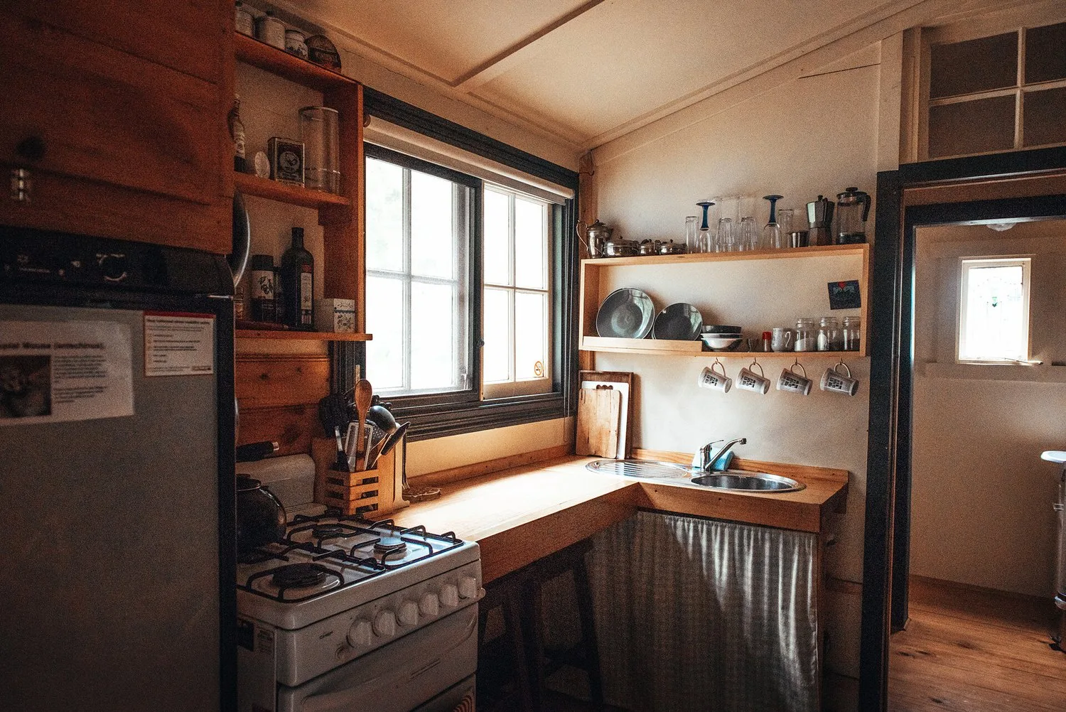 Timber kitchen cabinetry beneath a corner window.