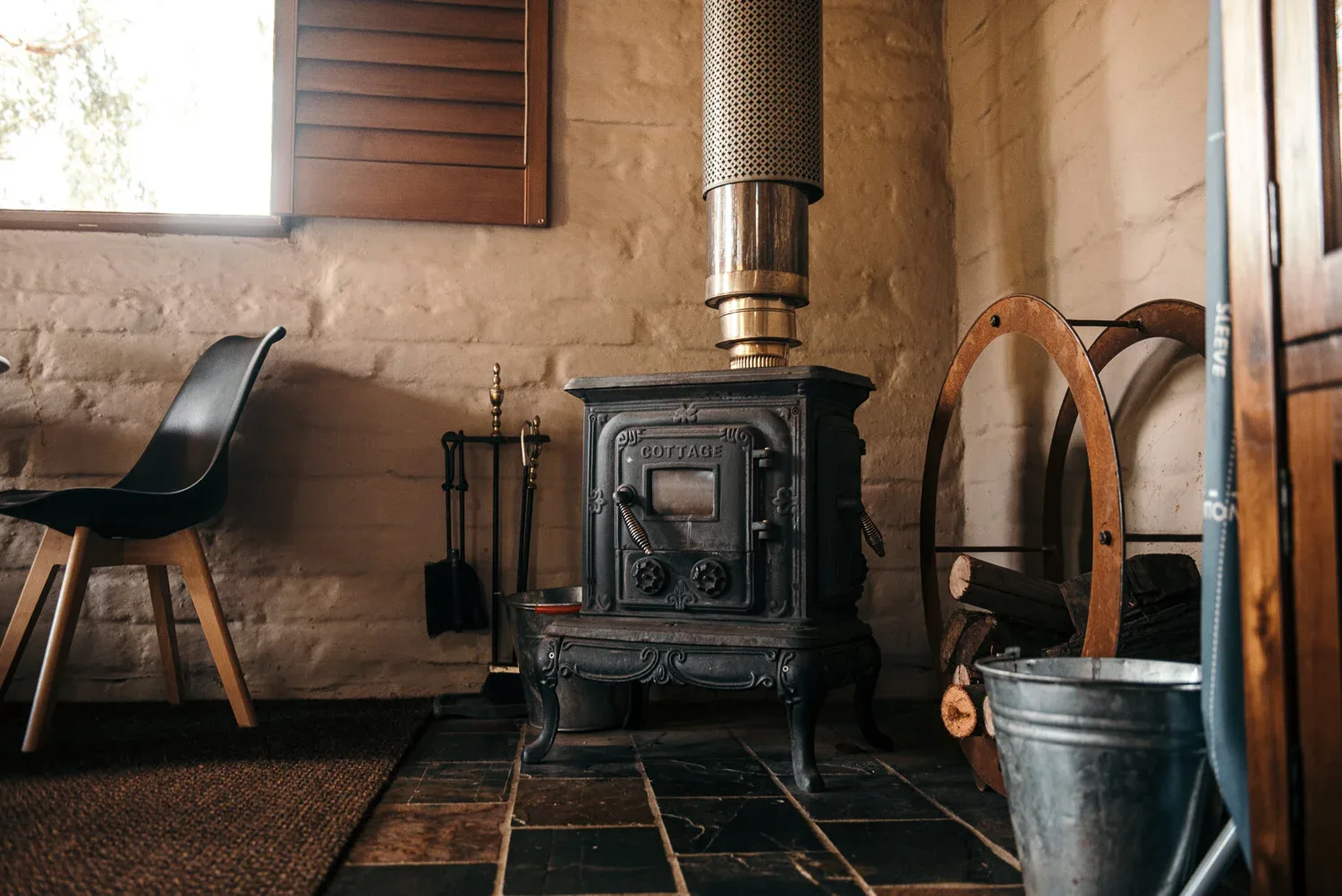 A dark stove against a pale textured wall.